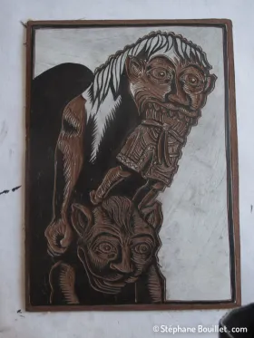 Fin de la gravure: avoir un dessin fortement contrasté en noir sur blanc permet d'être plus précis que noir sur le brun foncé du linoleum On ne suit pas forcément au millimètre le dessin de base, au contraire même: ne pas hésiter à rajouter ou modifier des traits pour utiliser toute la panoplie d'effets offerts par la linogravure (comme autour du nez et la machoire du personnage du dessus: j'ai laissé davantage de blanc = de partie qui seront noires)