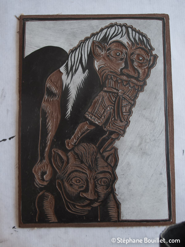 Fin de la gravure: avoir un dessin fortement contrasté en noir sur blanc permet d'être plus précis que noir sur le brun foncé du linoleum On ne suit pas forcément au millimètre le dessin de base, au contraire même: ne pas hésiter à rajouter ou modifier des traits pour utiliser toute la panoplie d'effets offerts par la linogravure (comme autour du nez et la machoire du personnage du dessus: j'ai laissé davantage de blanc = de partie qui seront noires)