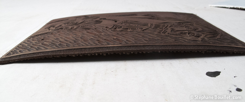 Les plaques de linoleum ont tendance à couber. Certains les fixent alors sur une plaque de bois, permettant aussi de délimiter des marges par rapport au papier utilisé, ainsi que de centrer la gravure